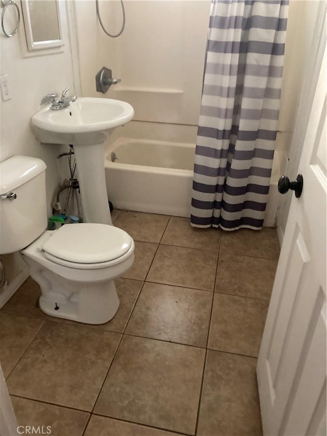 bathroom featuring tile patterned flooring, toilet, and shower / bathtub combination with curtain