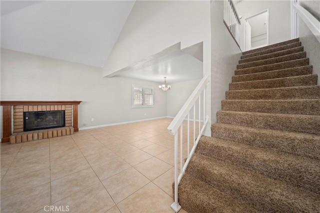 stairway featuring an inviting chandelier, high vaulted ceiling, a fireplace, and tile patterned floors