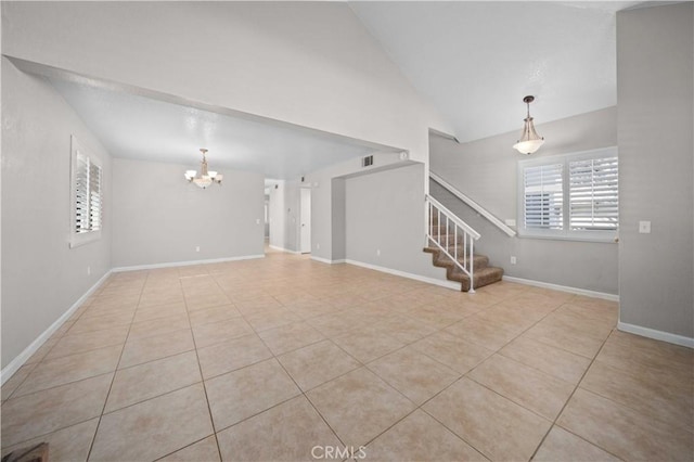 unfurnished living room with an inviting chandelier, high vaulted ceiling, and light tile patterned floors