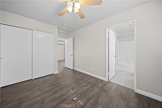 unfurnished bedroom with dark wood-type flooring, ceiling fan, connected bathroom, and a closet