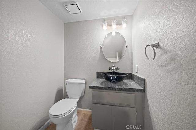 bathroom featuring vanity, tile patterned floors, and toilet