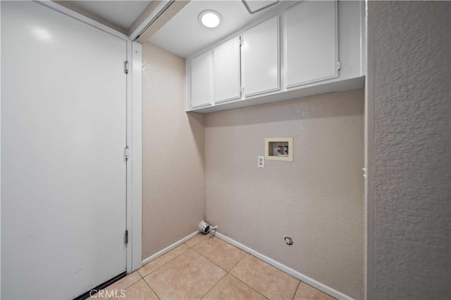 washroom featuring light tile patterned flooring, cabinets, gas dryer hookup, and hookup for a washing machine