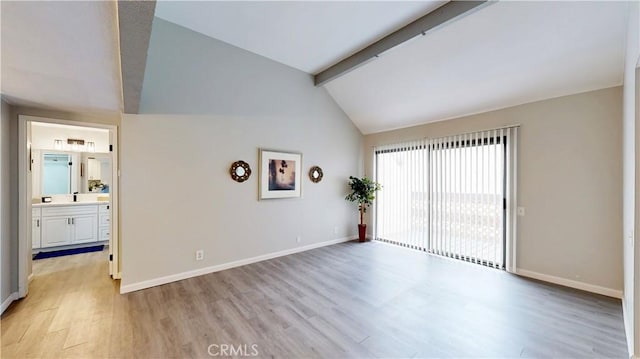 spare room featuring vaulted ceiling with beams and light hardwood / wood-style flooring