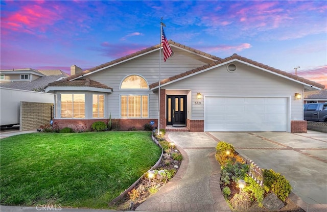 view of front of home featuring a garage and a yard