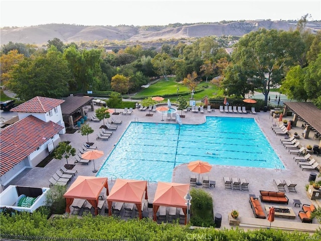 view of swimming pool featuring a mountain view and a patio area