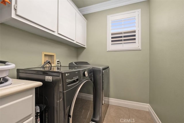 clothes washing area featuring light tile patterned flooring, cabinets, ornamental molding, and washer and dryer