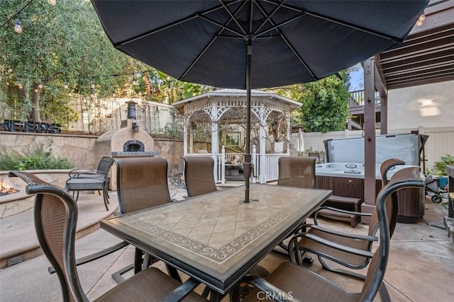 view of patio / terrace featuring a gazebo and exterior fireplace