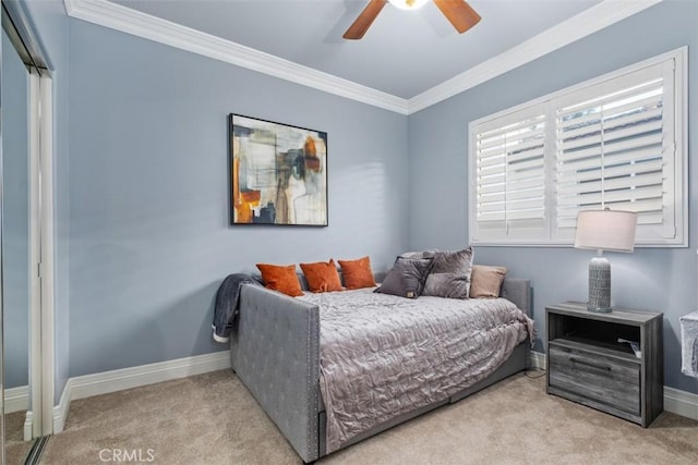 carpeted bedroom with ornamental molding and ceiling fan