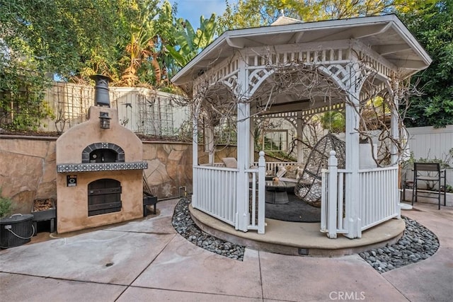 view of patio featuring a gazebo and an outdoor fireplace