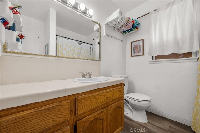 bathroom with hardwood / wood-style flooring, vanity, toilet, and decorative backsplash