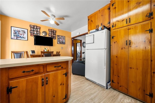 kitchen with white refrigerator, ceiling fan, and light hardwood / wood-style flooring