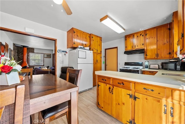 kitchen with sink, white appliances, ceiling fan, light hardwood / wood-style floors, and backsplash