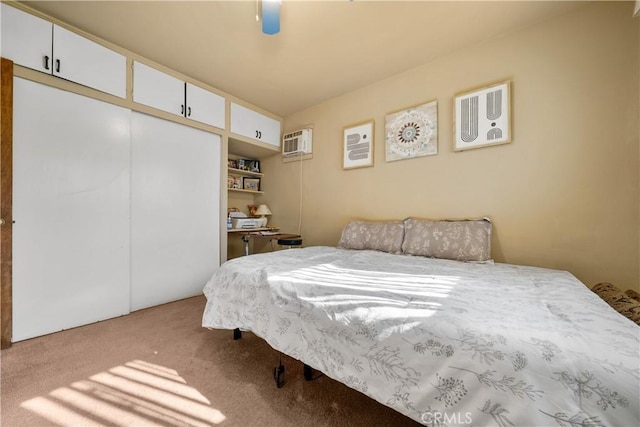 carpeted bedroom with ceiling fan, a closet, and an AC wall unit