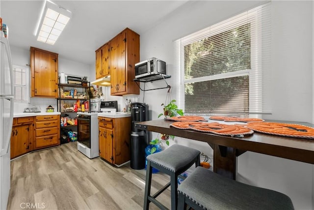 kitchen with white gas range and light wood-type flooring