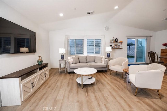 living room featuring lofted ceiling and light hardwood / wood-style flooring