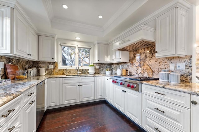 kitchen featuring premium range hood, a raised ceiling, sink, white cabinets, and stainless steel appliances