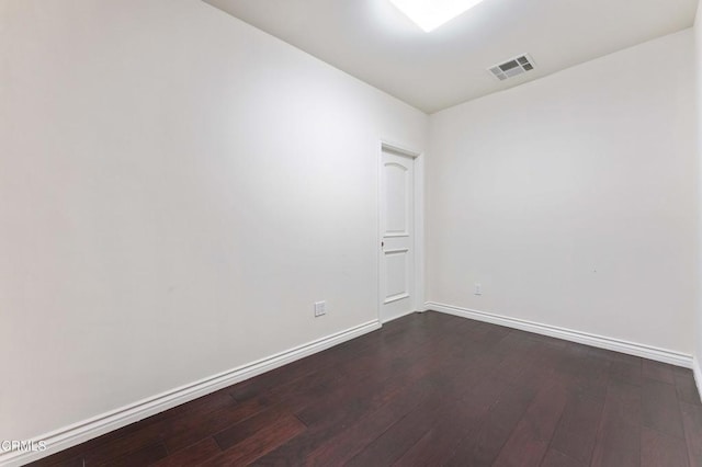 empty room with dark hardwood / wood-style flooring