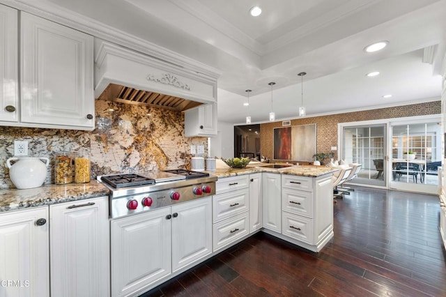 kitchen featuring hanging light fixtures, ornamental molding, white cabinets, kitchen peninsula, and stainless steel gas stovetop