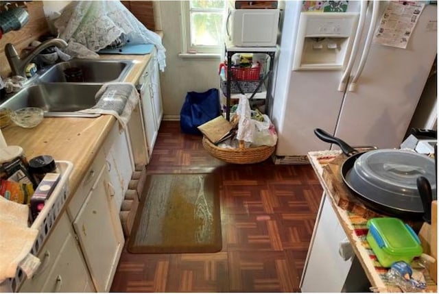 kitchen with white cabinetry, sink, dark parquet flooring, and white refrigerator with ice dispenser