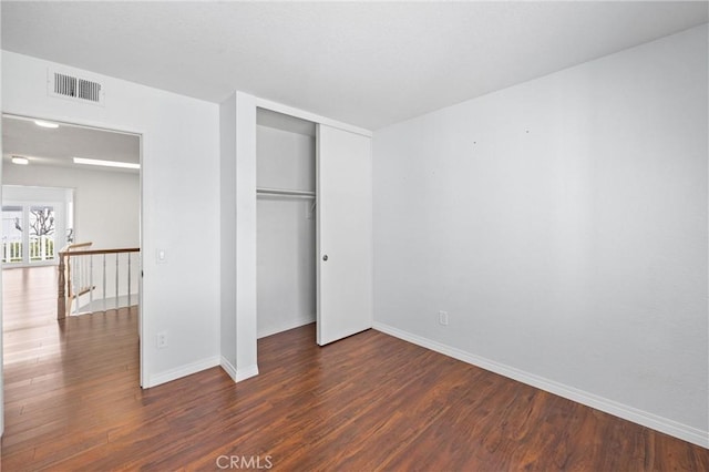 unfurnished bedroom featuring dark hardwood / wood-style floors and a closet