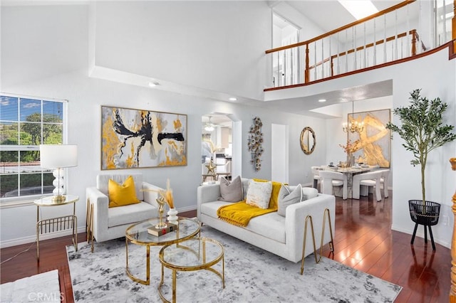 living room with dark hardwood / wood-style flooring, a notable chandelier, and a high ceiling