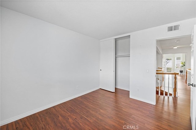 unfurnished bedroom featuring hardwood / wood-style flooring and a closet