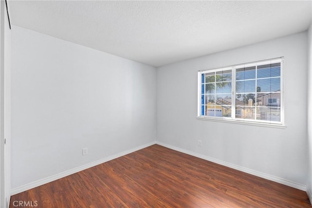 unfurnished room with dark hardwood / wood-style floors