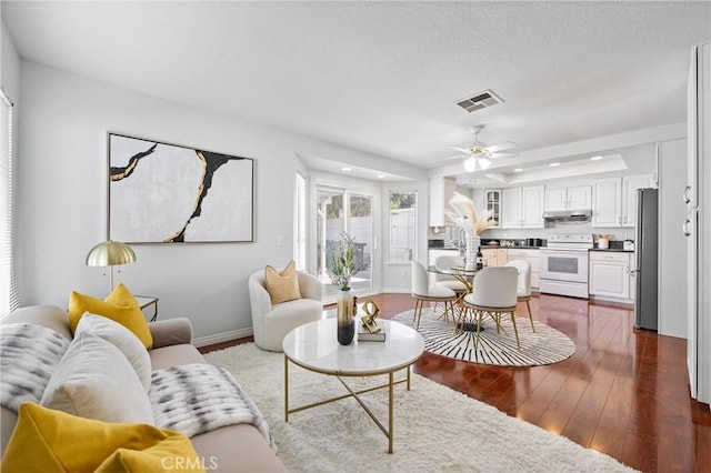 living room featuring dark hardwood / wood-style flooring and ceiling fan