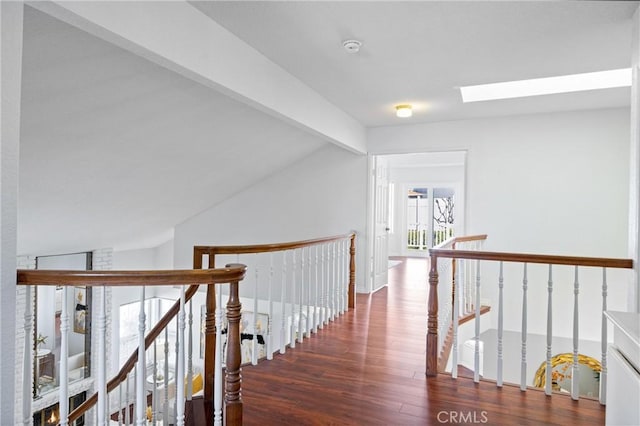 hallway featuring lofted ceiling with skylight and dark wood-type flooring