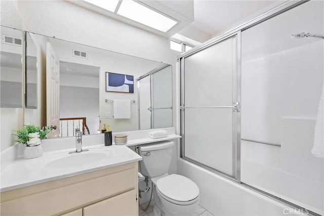 full bathroom featuring vanity, enclosed tub / shower combo, and toilet