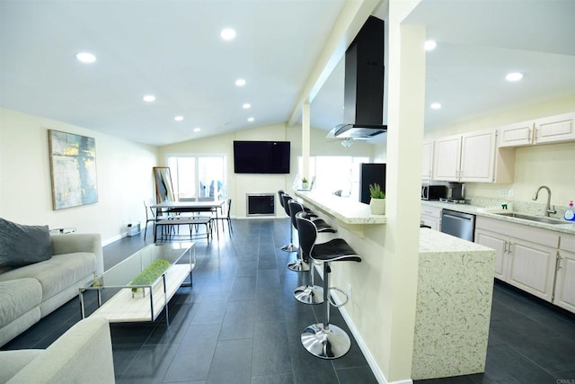 kitchen with dishwasher, lofted ceiling with beams, wall chimney exhaust hood, open floor plan, and a sink