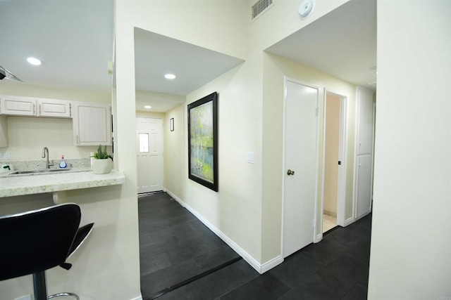 9452 Larrabee Ave, San Diego, CA 92123 - interior space with a sink, light stone counters, visible vents, white cabinetry, and baseboards