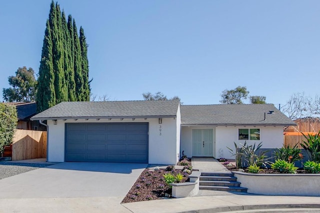 ranch-style house featuring a garage, fence, concrete driveway, and stucco siding