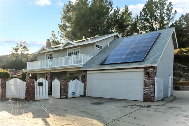 view of front of home with a garage, a balcony, and solar panels