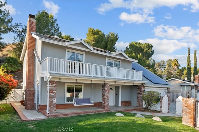 view of front of home with a front lawn, a patio, and a balcony