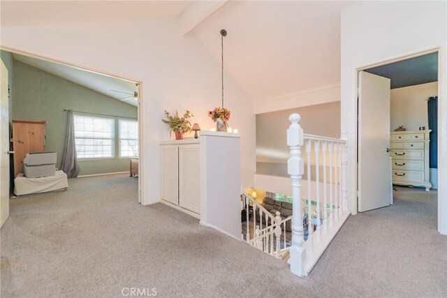 hallway with high vaulted ceiling, light colored carpet, and beamed ceiling