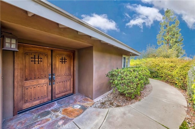 view of exterior entry with stucco siding