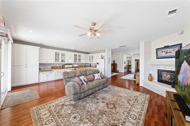 living room featuring dark wood-type flooring and ceiling fan