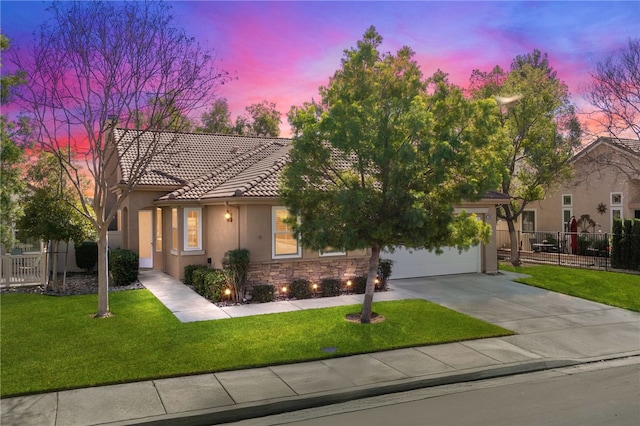 mediterranean / spanish-style home featuring a garage and a lawn