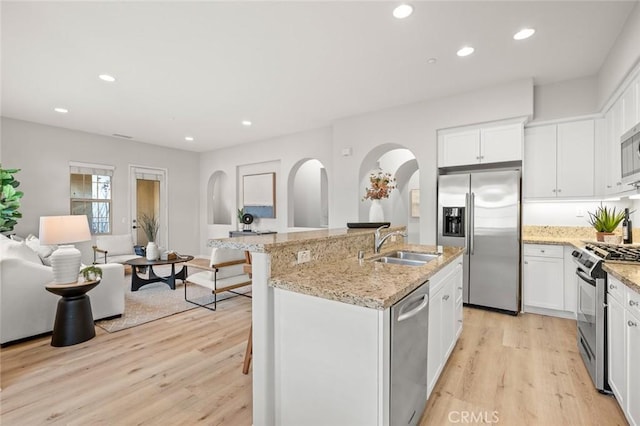 kitchen featuring sink, a breakfast bar area, white cabinetry, an island with sink, and stainless steel appliances