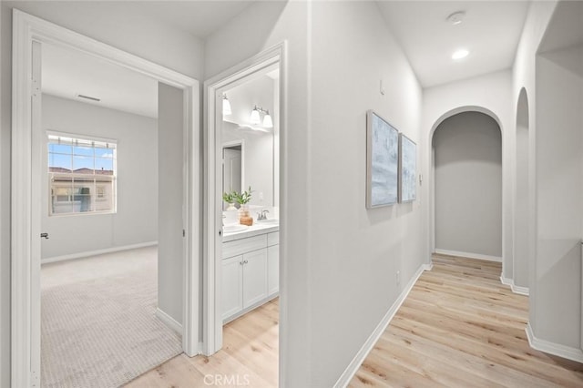 hall with sink and light hardwood / wood-style flooring