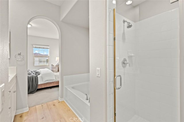 bathroom featuring independent shower and bath and hardwood / wood-style floors