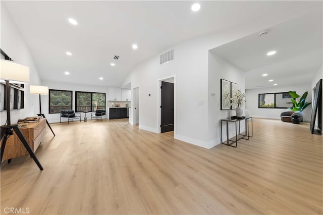 living room featuring vaulted ceiling and light hardwood / wood-style flooring