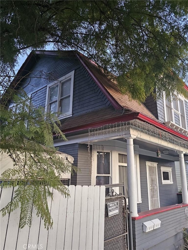 view of side of property featuring cooling unit and covered porch