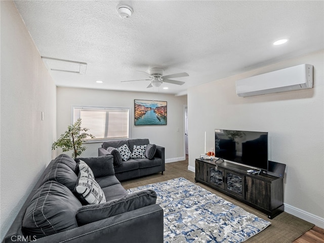 living room with wood-type flooring, ceiling fan, a textured ceiling, and a wall unit AC