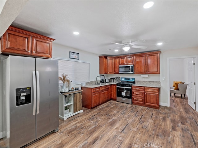 kitchen featuring dark hardwood / wood-style flooring, sink, ceiling fan, and appliances with stainless steel finishes