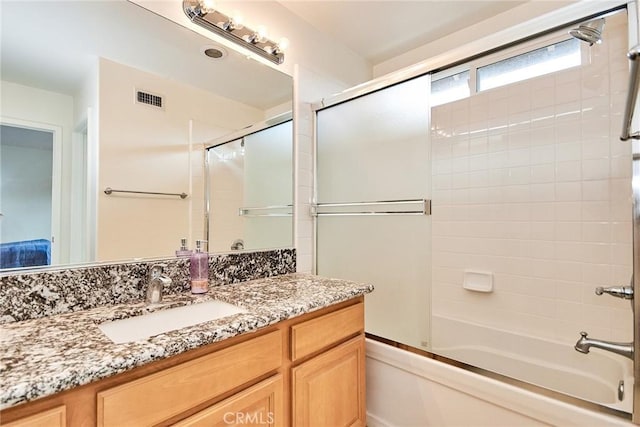 bathroom with shower / bath combination with glass door and vanity