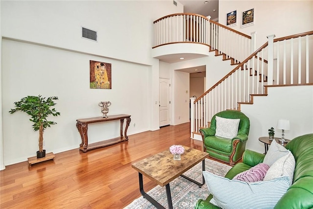 living room featuring hardwood / wood-style floors and a towering ceiling