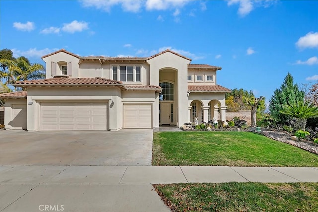 mediterranean / spanish house with a garage and a front lawn