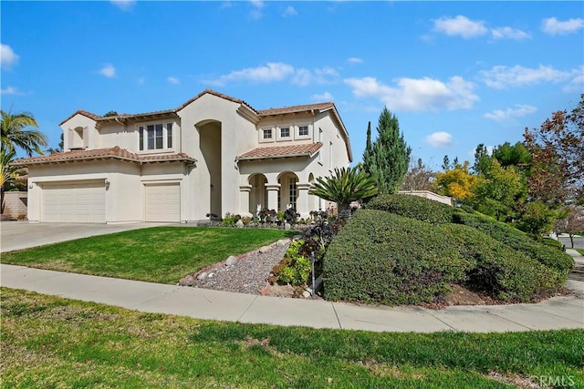 mediterranean / spanish house with a garage and a front yard